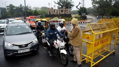 Delhi Police personnel stopping vehicles at a road checkpoint as Delhi is under a weekend curfew.&nbsp; (ANI)