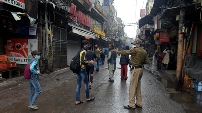 A policeman directs pedestrians to return home during weekend curfew imposed to curb the spread of the coronavirus in New Delhi. (AP) A policeman directs pedestrians to return home during weekend curfew imposed to curb the spread of the coronavirus in New Delhi. (AP)