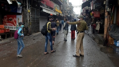 A policeman directs pedestrians to return home during weekend curfew imposed to curb the spread of the coronavirus in New Delhi. (AP) A policeman directs pedestrians to return home during weekend curfew imposed to curb the spread of the coronavirus in New Delhi. (AP)