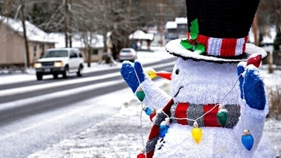 Snow accumulates on the hat of a friendly snowman as he greets motorists along Northeast 159th Street in Hockinson, Wash (AP) Snow accumulates on the hat of a friendly snowman as he greets motorists along Northeast 159th Street in Hockinson, Wash (AP)