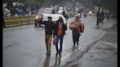 Pedestrians use a piece of plastic sheet to cover themselves from rain, on a stretch at Sector 10A in Gurugram on Saturday. (Parveen Kumar/HT) Pedestrians use a piece of plastic sheet to cover themselves from rain, on a stretch at Sector 10A in Gurugram on Saturday. (Parveen Kumar/HT)