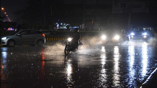 Commuters manoeuvring through a waterlogged road amid the rain in Panchkula on Saturday. (Sant Arora/HT)