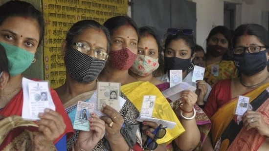 Women show their voter ID cards as they stand in a queue to cast their vote at a polling station during phase 5 of last year's West Bengal assembly elections (PTI PHOTO.)