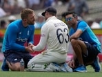 England's Jos Buttler, center, is treated for an injury in a break in play during the second day of their Ashes cricket test match against Australia in Sydney, Thursday, Jan. 6, 2022. England's Jos Buttler, center, is treated for an injury in a break in play during the second day of their Ashes cricket test match against Australia in Sydney, Thursday, Jan. 6, 2022.