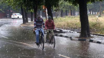 Cyclists braving the rain in Sector 34, Chandigarh, on Sunday. (Sanjeev Sharma/HT)