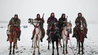 Taliban fighters pose for pictures while riding rental horses during a snowfall at the Qargha lake in Kabul. (AFP) Taliban fighters pose for pictures while riding rental horses during a snowfall at the Qargha lake in Kabul. (AFP)