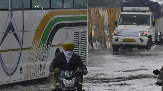 Vehicles wade through water logging Road after rain at Bhai Bala Chowk in Ludhiana on January 08, 2022. (Harsimar Pal Singh/HT)