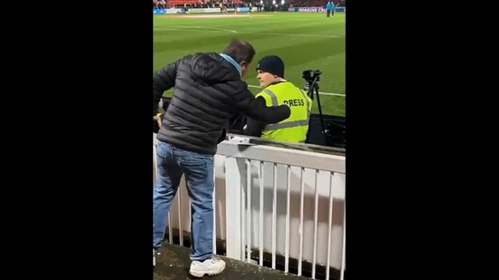 The Manchester City fan, 'pressing' the back of a jacket of a member of the press.&nbsp;(twitter/@Citizen_baker)
