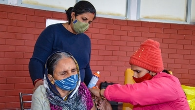 A health worker administers a booster dose of Covid-19 vaccine to a beneficiary in Gurugram. (PTI) A health worker administers a booster dose of Covid-19 vaccine to a beneficiary in Gurugram. (PTI)