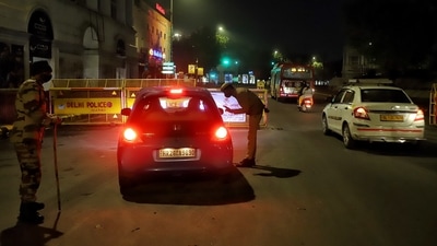 Delhi Police personnel stop a vehicle during a weekend curfew imposed by the Delhi government amid rising Covid-19 cases, at Connaught place on Sunday. (ANI Photo) Delhi Police personnel stop a vehicle during a weekend curfew imposed by the Delhi government amid rising Covid-19 cases, at Connaught place on Sunday. (ANI Photo)