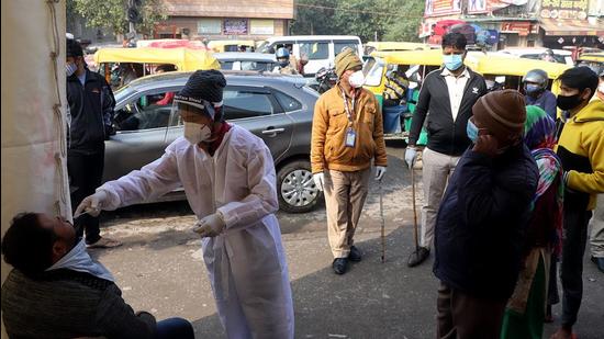 A healthcare worker collects a nasal swab sample of a man for the Covid-19 test amid a surge in Covid-19 and Omicron cases, in New Delhi on Monday. (AN)