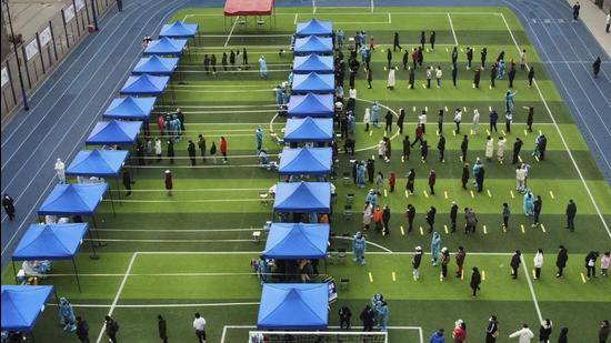 Residents line up on a football field for the coronavirus test in north China’s Tianjin municipality, on Sunday. At least 21 more cases of were reported in the port city of Tianjin, some 130km away from Beijing, the national health commission said . (AP)