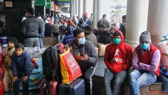 Passengers waiting during a weekend curfew imposed by Delhi government following a surge in Covid-19 cases, at New Delhi Railway Station on Sunday.(ANI Photo)