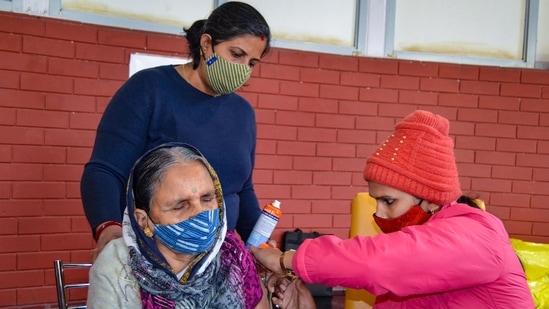A health worker administers a booster dose of Covid-19 vaccine to a beneficiary in Gurugram.(PTI)
