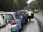 A woman in line at a Covid-19 testing centre steps out of her vehicle.