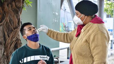 A health worker collects swab samples from a resident for Covid testing near Sarabha Nagar Market in Ludhiana on Tuesday. (Gurpreet Singh/HT)