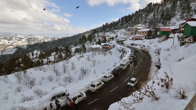 Tourists park their vehicles on the roadside and enjoy playing in the snow at Kufri in Shimla. (ANI)
