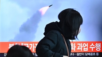 People walk past a television screen showing a news broadcast with file footage of a North Korean missile test, at a railway station in Seoul on January 11, 2022, after North Korea fired a "suspected ballistic missile" into the sea,&nbsp; (AFP)