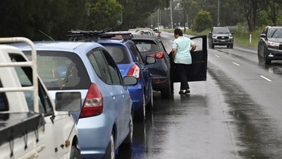 A woman in line at a Covid-19 testing centre steps out of her vehicle. (Reuters Photo)
