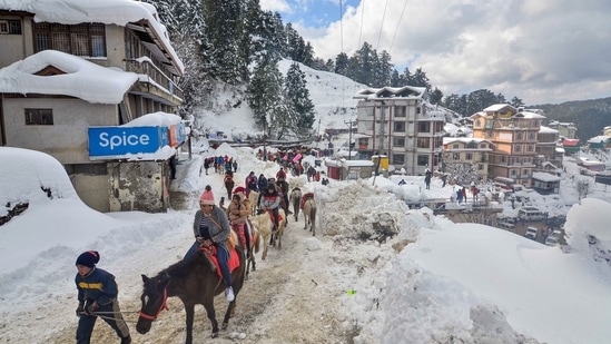 Tourists ride horses after heavy snowfall at Kufri near Shimla paints the town in white.(PTI)
