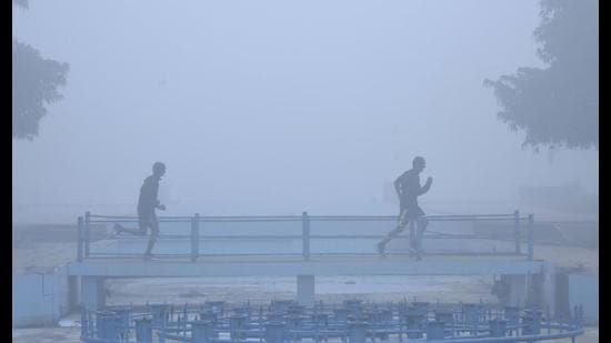 People exercise on a cold winter morning in foggy conditions at a park in Gurugram on Tuesday. (Vipin Kumar /HT PHOTO) People exercise on a cold winter morning in foggy conditions at a park in Gurugram on Tuesday. (Vipin Kumar /HT PHOTO)
