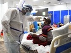 A health worker in a PPE kit checks a Covid-19 patient at Covid Care Centre, Commonwealth Games Village, in New Delhi.