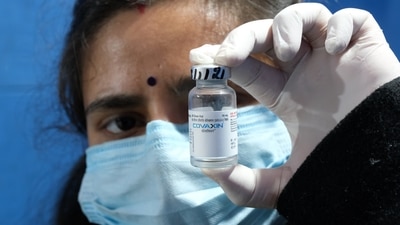 A health worker, in a vaccination centre in New Delhi, help up a file of covid-19 vaccine. India is currently experiencing a surge in covid transmissions due to the new variant - Omicron. (Bloomberg) A health worker, in a vaccination centre in New Delhi, help up a file of covid-19 vaccine. India is currently experiencing a surge in covid transmissions due to the new variant - Omicron. (Bloomberg)