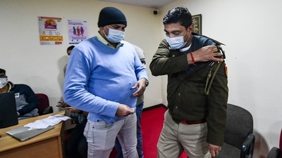 A Delhi police person after being administered a booster dose of COVID-19 vaccine at RML hospital in New Delhi. (PTI) A Delhi police person after being administered a booster dose of COVID-19 vaccine at RML hospital in New Delhi. (PTI)