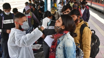 A BMC health worker collects swab samples of an outstation passenger for Covid-19 test at CSMT Station in Mumbai. (PTI)