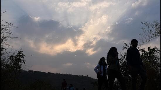 People on Pashan tekdi at Pashan-Sus road under cloudy evening in Pune, on Wednesday. Pune city witnessed a further drop in night temperatures on Wednesday, when Shivajinagar reported a minimum temperature of 11.4 degrees Celsius. (HT)