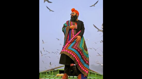 Fashion designer Param Sahib throws on a bright rainbow-hued shawl over his black separates (parambanana/Instagram)