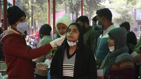A health worker collects swab samples of a woman for Covid test, in Ghaziabad on Wednesday. (Sakib Ali /HT) A health worker collects swab samples of a woman for Covid test, in Ghaziabad on Wednesday. (Sakib Ali /HT)