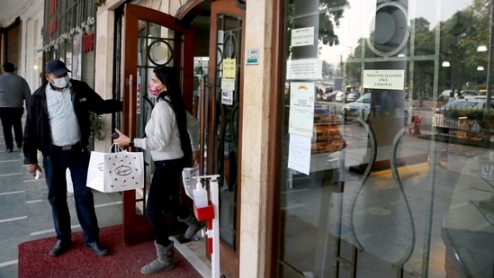 A woman leaves after picking up her order from a restaurant in Connaught Place as the Delhi government has shut down dine-in services in restaurants.(ANI Photo)