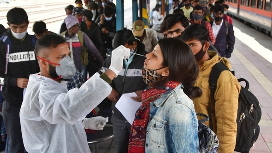 A BMC health worker collects swab samples of an outstation passenger for Covid-19 test at CSMT Station in Mumbai.(PTI) A BMC health worker collects swab samples of an outstation passenger for Covid-19 test at CSMT Station in Mumbai.(PTI)