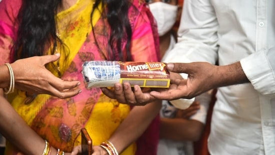 Nalla Vijay presenting the saree he wove that can fit into a matchbox.&nbsp;(twitter/@MinisterKTR)