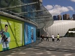 People exit a building with an image of Serbian tennis player Novak Djokovic as questions remain over the legal battle regarding his visa to play in the Australian Open, at Melbourne Park in Melbourne, Australia, January 12, 2022.