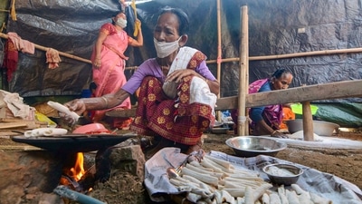 Women in traditional attires prepare pithas ahead of the Bhogali Bihu festival in Guwahati to mark the end of the harvesting season. (PTI) Women in traditional attires prepare pithas ahead of the Bhogali Bihu festival in Guwahati to mark the end of the harvesting season. (PTI)