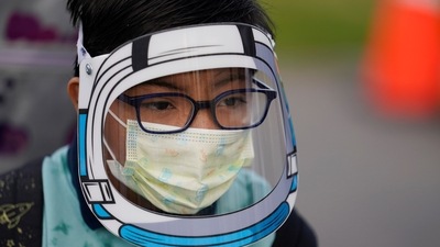 A student wears a mask and face shield while waiting for the first bell amid the Covid-19 pandemic at Washington Elementary School in Lynwood, Calif. (AP) A student wears a mask and face shield while waiting for the first bell amid the Covid-19 pandemic at Washington Elementary School in Lynwood, Calif. (AP)