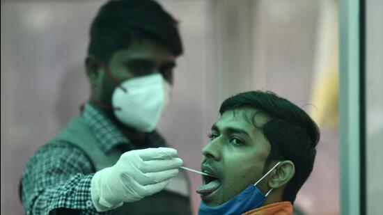 Noida, India - January 13, 2022: A health worker collects a swab sample for Rt Pcr Covid-19 test, at district hospital, sector 30, in Noida, India, on Thursday, January 13, 2022. (Photo by Sunil Ghosh / Hindustan Times)