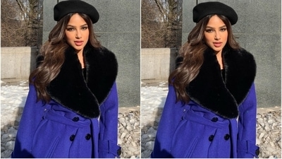 The pictures show Harnaaz wearing a blue overcoat over her day-out ensemble. It features black faux fur on the exaggerated collars, long sleeves, a tie-around to cinch the coat on the waist, knee-length hem and black button closures on the front. Harnaaz teamed it with brown knee-high leather boots, cat-eye sunglasses and a matching beret. (Instagram/@harnaazsandhu_03) The pictures show Harnaaz wearing a blue overcoat over her day-out ensemble. It features black faux fur on the exaggerated collars, long sleeves, a tie-around to cinch the coat on the waist, knee-length hem and black button closures on the front. Harnaaz teamed it with brown knee-high leather boots, cat-eye sunglasses and a matching beret. (Instagram/@harnaazsandhu_03)