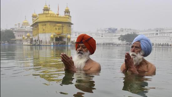 Devotees taking a holy dip at the sarovar in Golden Temple complex on Friday on the occasion of Makar Sankranti. (Sameer Sehgal/HT)