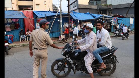 A policeman catches motorist for not wearing a mask in Kalyan. KDMC has fined 744 persons for not wearing masks and collected a fine worth <span class='webrupee'>₹</span>3.72 lakh this year so far. 92% of active Covid cases in Kalyan Dombivli Municipal Corporation limits are under home isolation. (RISHIKESH CHOUDHARY/HT PHOTO)
