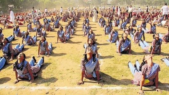 Students performing Surya Namaskar, a form of Yoga, at Mulund Sambhaji ground in Mumbai.(Praful Gangurde/HT File Photo)