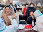 Medical workers wearing protective suits swab a woman and a child for a coronavirus test in Huaxian County in central China's Henan Province.(AP) Medical workers wearing protective suits swab a woman and a child for a coronavirus test in Huaxian County in central China's Henan Province.(AP)