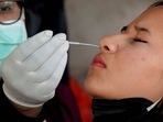 A healthcare worker collects a swab sample of a pedestrian for COVID-19 test, amid a surge in Omicron cases.(PTI) A healthcare worker collects a swab sample of a pedestrian for COVID-19 test, amid a surge in Omicron cases.(PTI)
