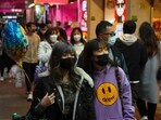 People wearing face masks to protect against the spread of the coronavirus, walk on a street in Hong Kong. Hong Kong International Airport said that it would ban passengers from over 150 countries and territories from transiting in the city for a month, as it sought to stem the transmission of the highly contagious Omicron variant of the coronavirus  (AP Photo/Kin Cheung)