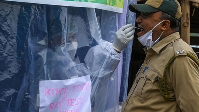 A health worker collects swab samples from a policeman for Covid-19. (AFP)