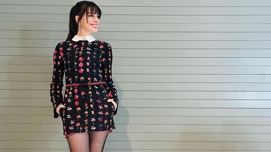 Sporting a contrasting white collar, pockets on either side and a waist belt detailing, the dress was given a winter look with a pair of black boots from Giuseppe Zanotti and a black trench coat. The coat and the dress both are credited to Italian luxury fashion house, Valentino.(Instagram/annehathaway)