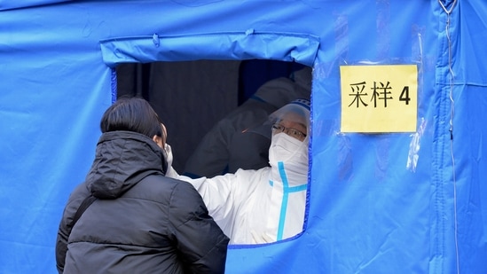 A medical worker wearing a protective suit swabs a woman for a coronavirus test in northern China's Tianjin municipality on Saturday.&nbsp;(AP)