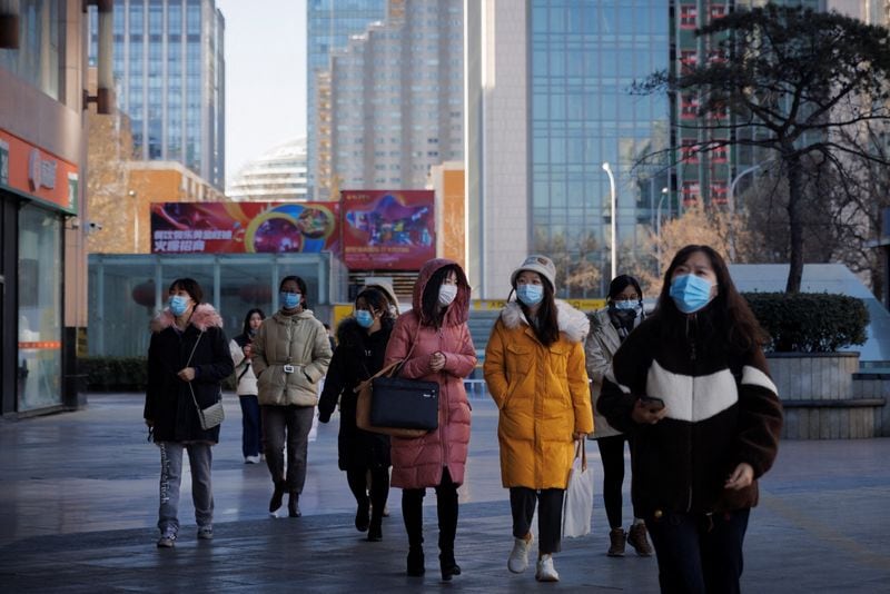 People walk on a street as the coronavirus disease (Covid-19) outbreak continues in Beijing, China.&nbsp; (Reuters)